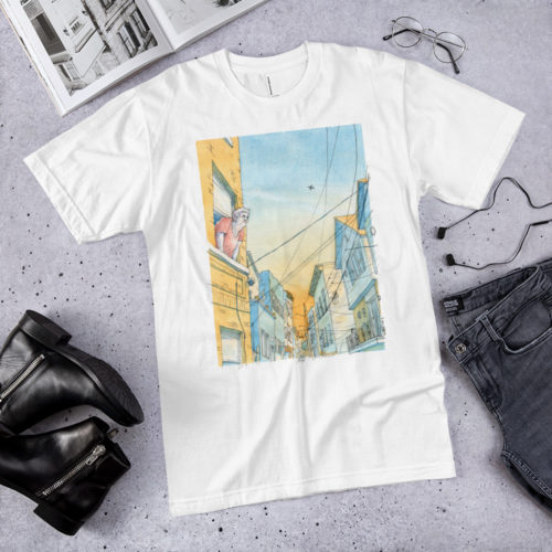 A white shirt with a watercolor illustration of an old lady looking out an apartment window in Union City, NJ. It's on the floor with stuff around it. By Kenny Velez