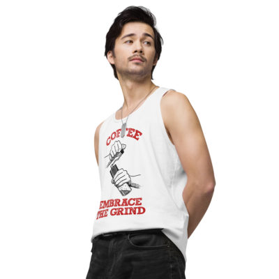 A guy wearing a white tank top with a drawing of hands using a handheld coffee grinder with the words COFFEE EMBRACE THE GRIND. Designed by Kenny Velez