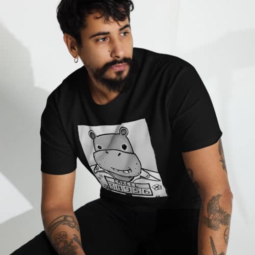 a guy wearing a black t-shirt with a drawing of a mugshot featuring a cartoon hippo in a Hawaiian shirt in the vein of the iconic mugshot of Pablo Escobar. Designed by Kenny Velez.