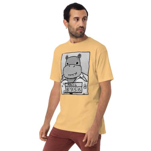 a guy wearing a yellow t-shirt with a drawing of a mugshot featuring a cartoon hippo in a Hawaiian shirt in the vein of the iconic mugshot of Pablo Escobar. Designed by Kenny Velez.