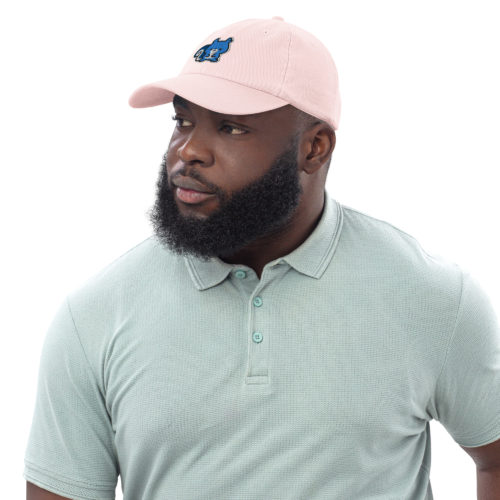 A man wearing a pink pastel baseball hat with a cute blue squirrel embroidery. Ma Squirrel by Kenny Velez is the brand.