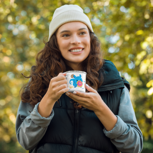 a woman holding a white camper mug with a cute cartoon squirrel eating a doughnut and surrounded by donuts with the words nom