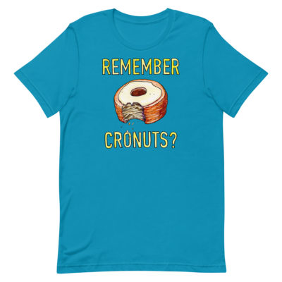 a blue t-shirt with a drawing of a bitten cronut with the words REMEMBER CRONUTS? in yellow lettering. Designed by Kenny Velez.