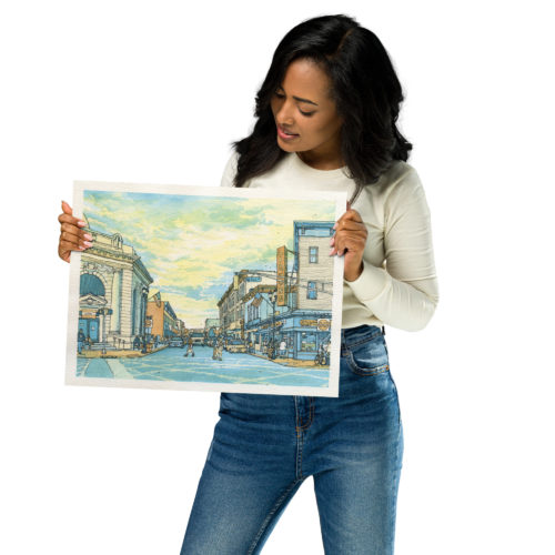 a woman holding a print of a watercolor painting of Union City, NJ at Bergenline and 32nd St.
