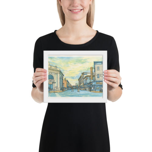 a woman holding a framed poster of a watercolor painting of Union City, NJ at Bergenline and 32nd St.