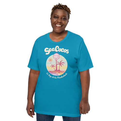 a woman wearing a blue t-shirt with a drawing of the water tower from Secaucus, NJ on a beach, with the words Sea Cocos, La Joya de los Meadowlands. Designed by Kenny Velez.