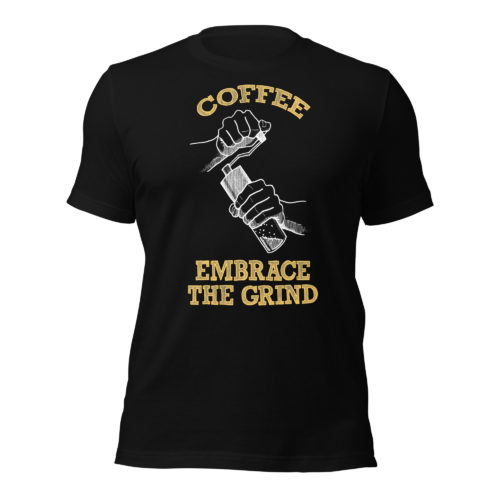 A black t-shirt with a drawing of hands using a handheld coffee grinder with the words COFFEE EMBRACE THE GRIND in yellow lettering. Designed by Kenny Velez