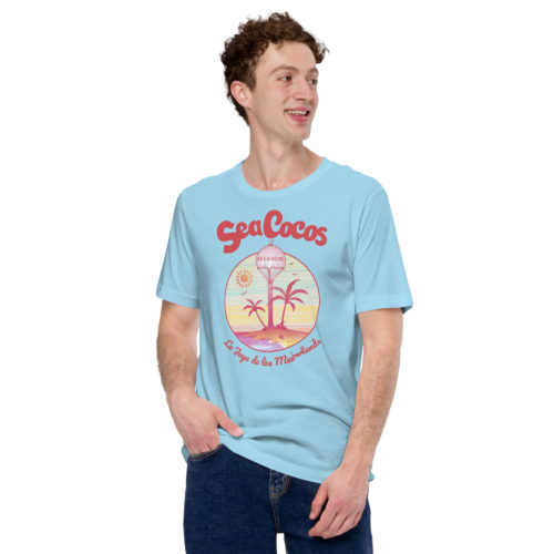 a guy wearing a blue t-shirt with a drawing of the water tower from Secaucus, NJ on a beach, with the words Sea Cocos, La Joya de los Meadowlands. Designed by Kenny Velez.