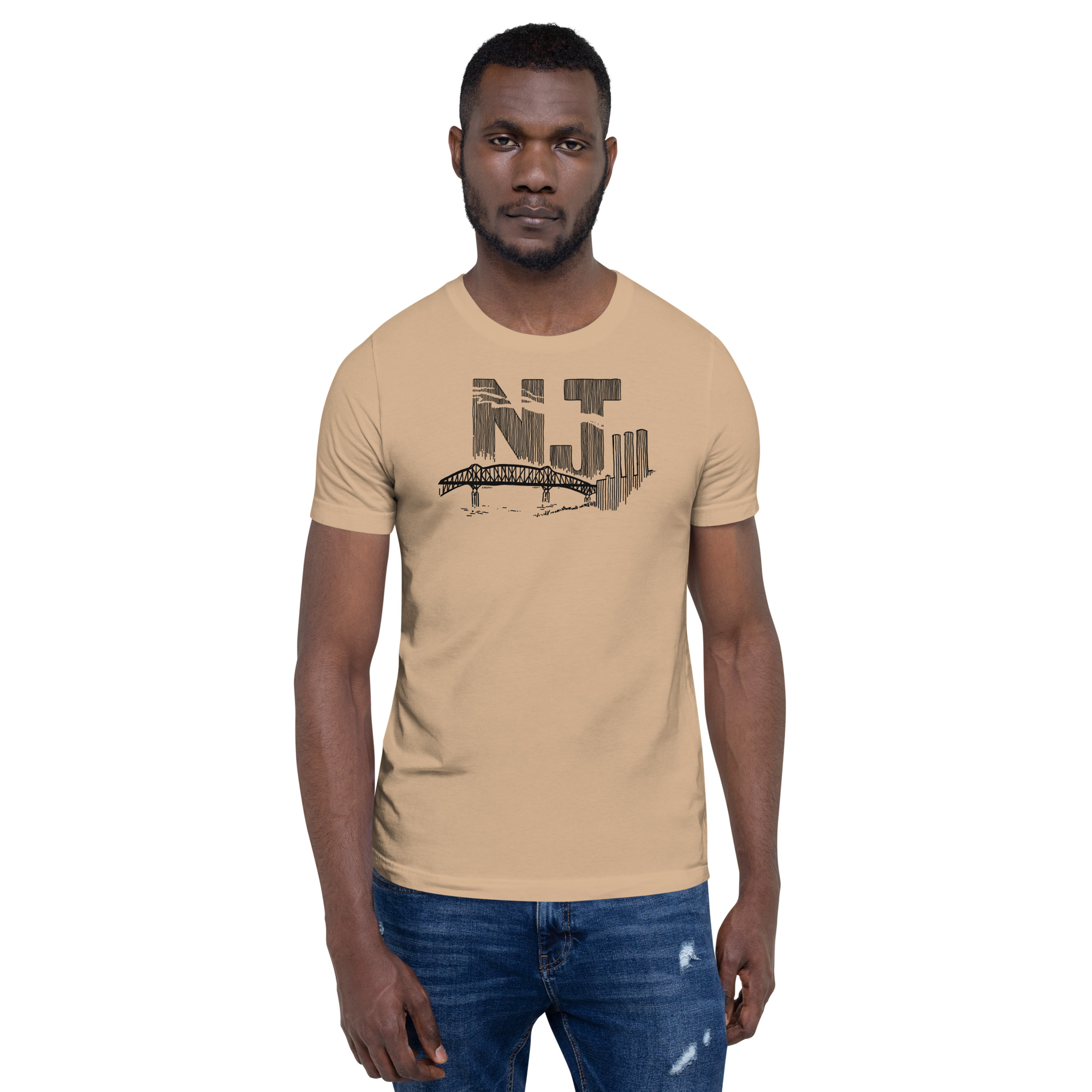 A man wearing a tan t-shirt with a line drawing of the Pulaski Skyway and Kearny power plant with the initials NJ. Designed by Kenny Velez.