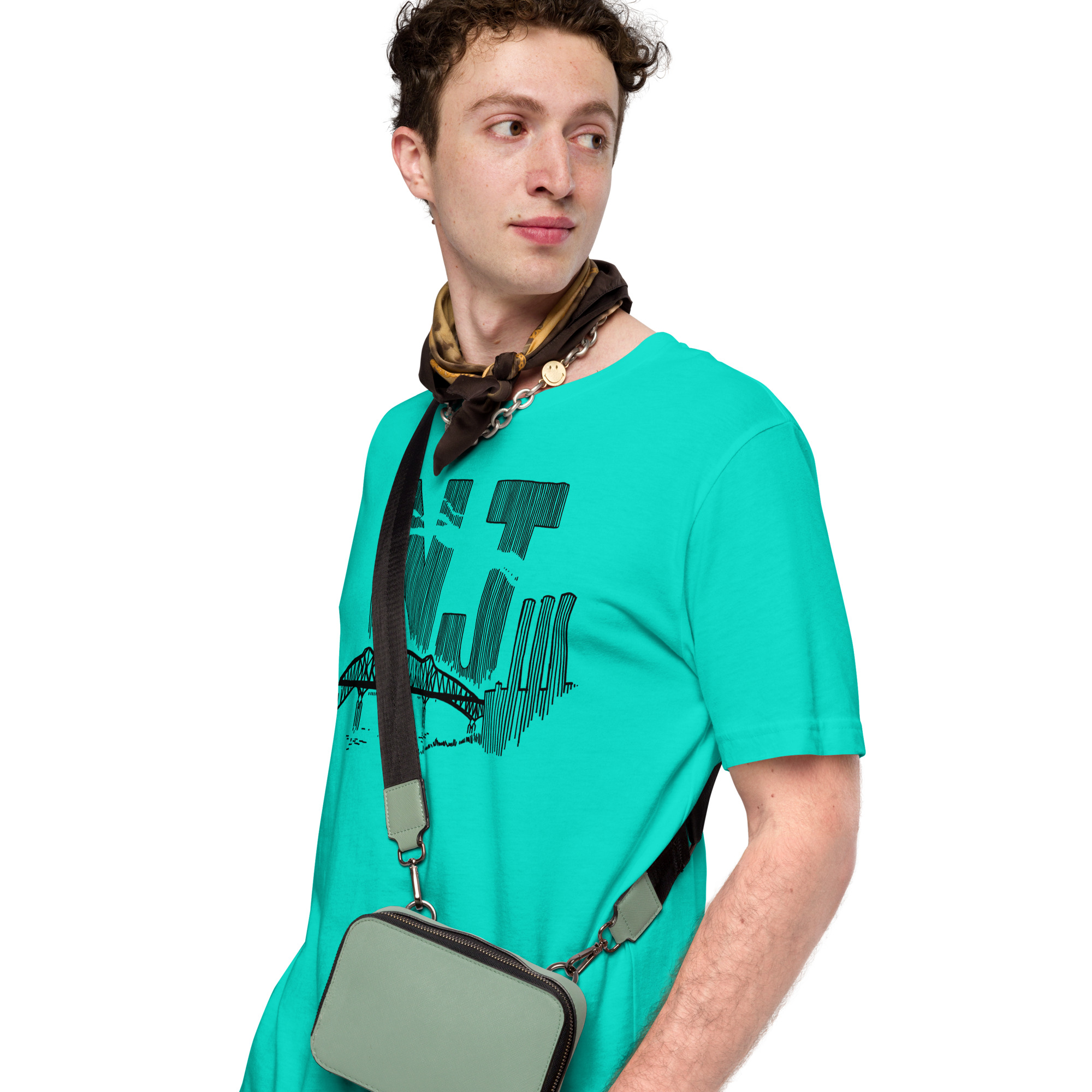 A man wearing a teal t-shirt with a line drawing of the Pulaski Skyway and Kearny power plant with the initials NJ. Designed by Kenny Velez.